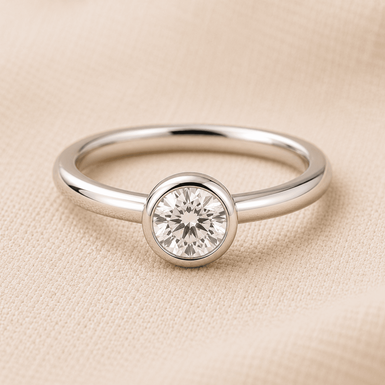 Women's bezel set engagement ring on cream linen at ATL Luxury Jewelers Atlanta