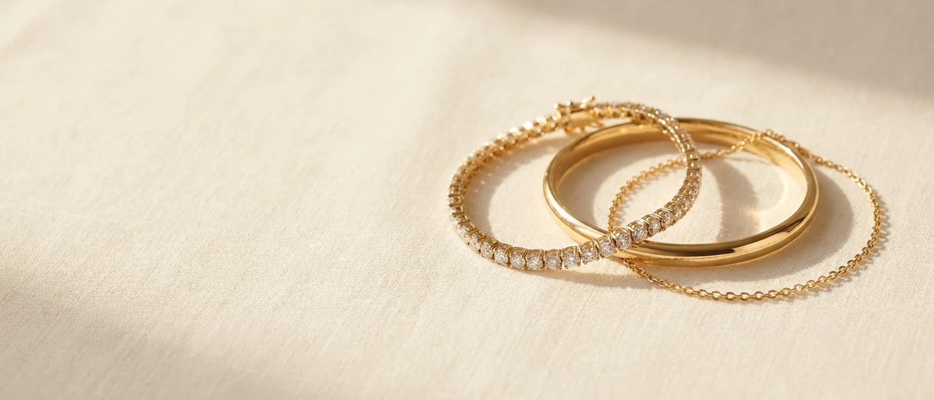 14K gold bracelets on cream linen at ATL Luxury Jewelry Atlanta