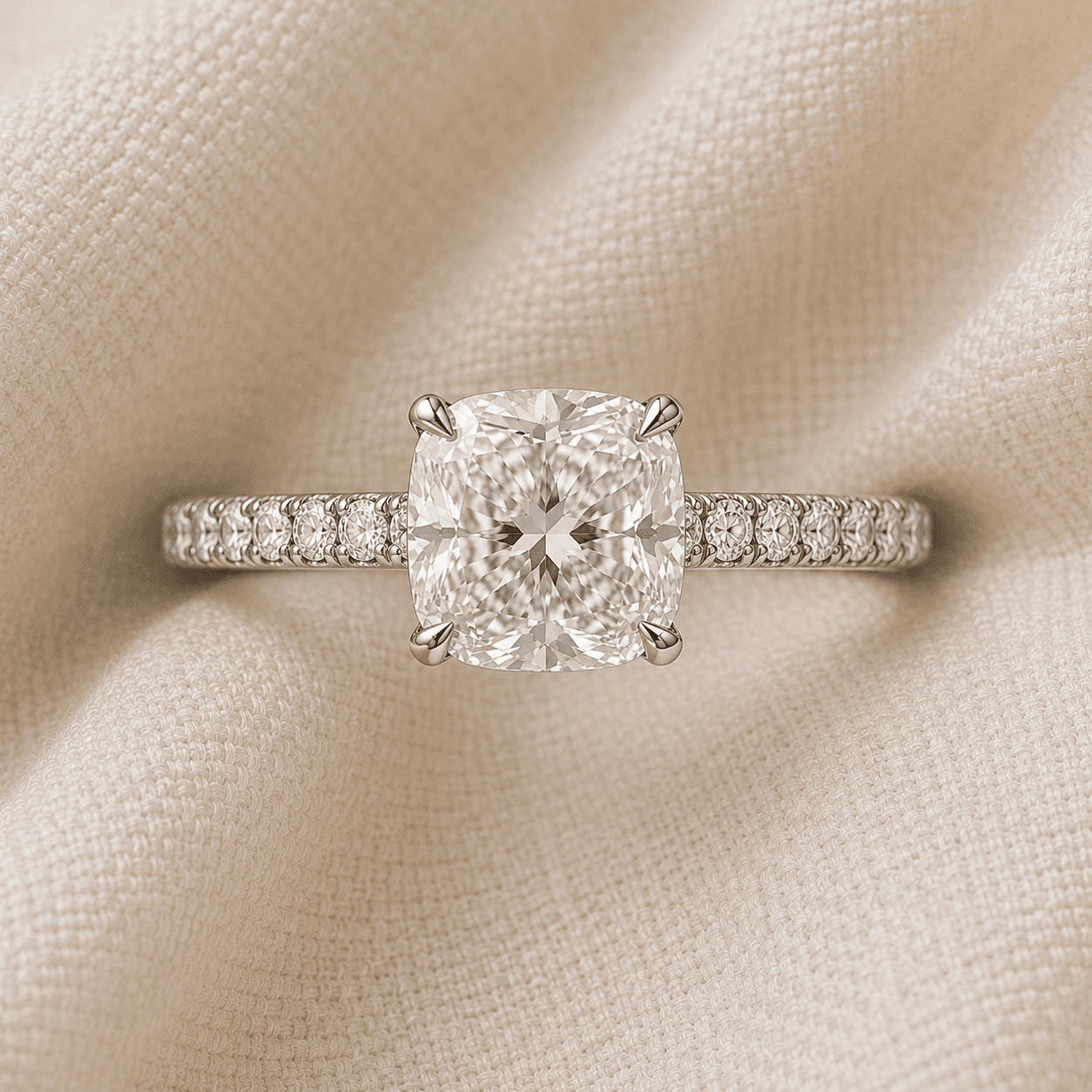 Cushion cut engagement ring with pavé diamond band in platinum