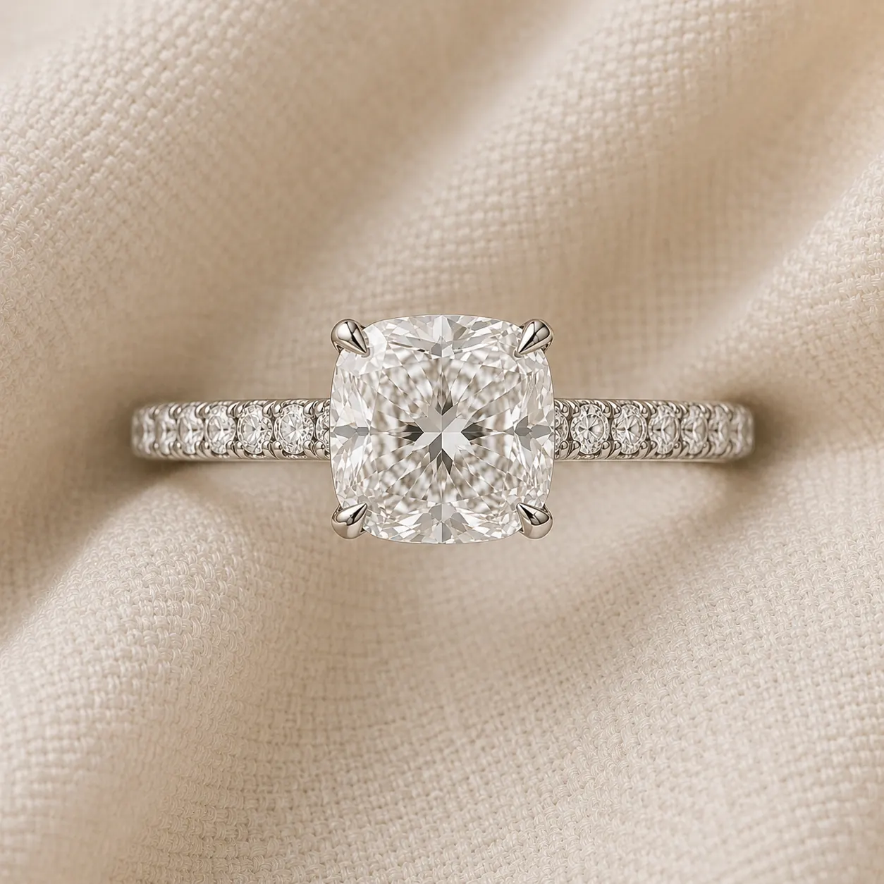 Cushion cut engagement ring with pavé diamond band in platinum