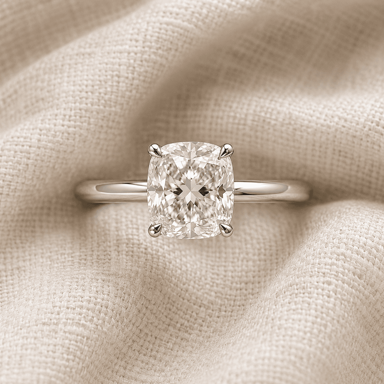 Cushion cut solitaire engagement ring with four-prong setting in white gold
