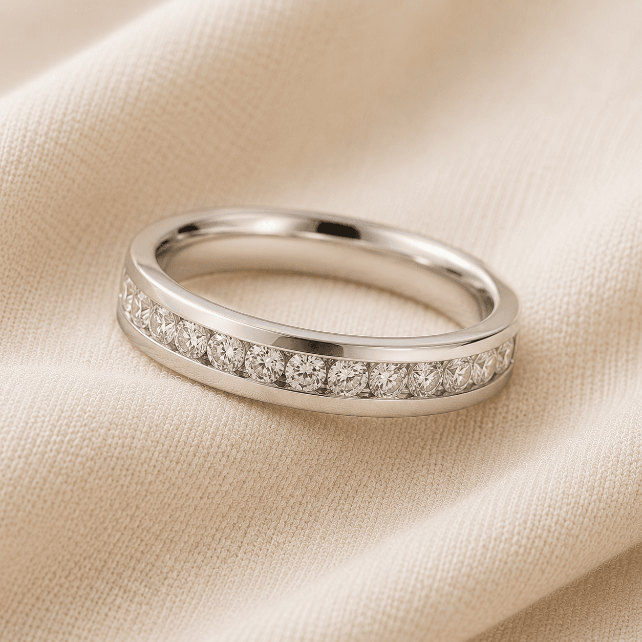 Channel-set diamond wedding band in white gold with diamonds flush between two metal rails on cream linen at ATL Luxury Jewelers Atlanta