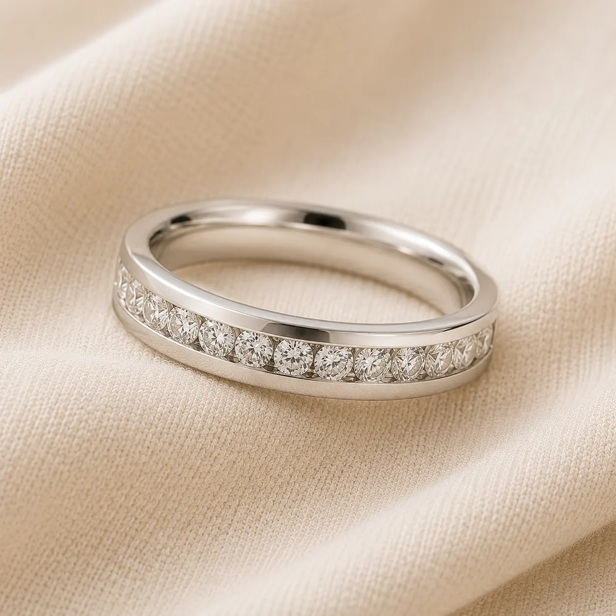 Channel-set diamond wedding band in white gold with diamonds flush between two metal rails on cream linen at ATL Luxury Jewelry Atlanta