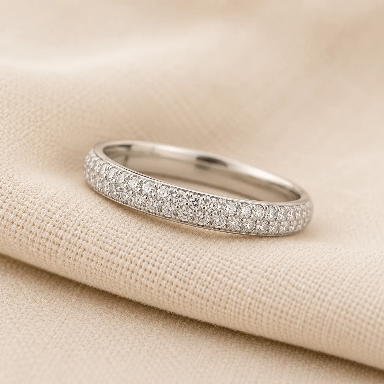 Platinum diamond pavé wedding band on cream linen at ATL Luxury Jewelry Atlanta