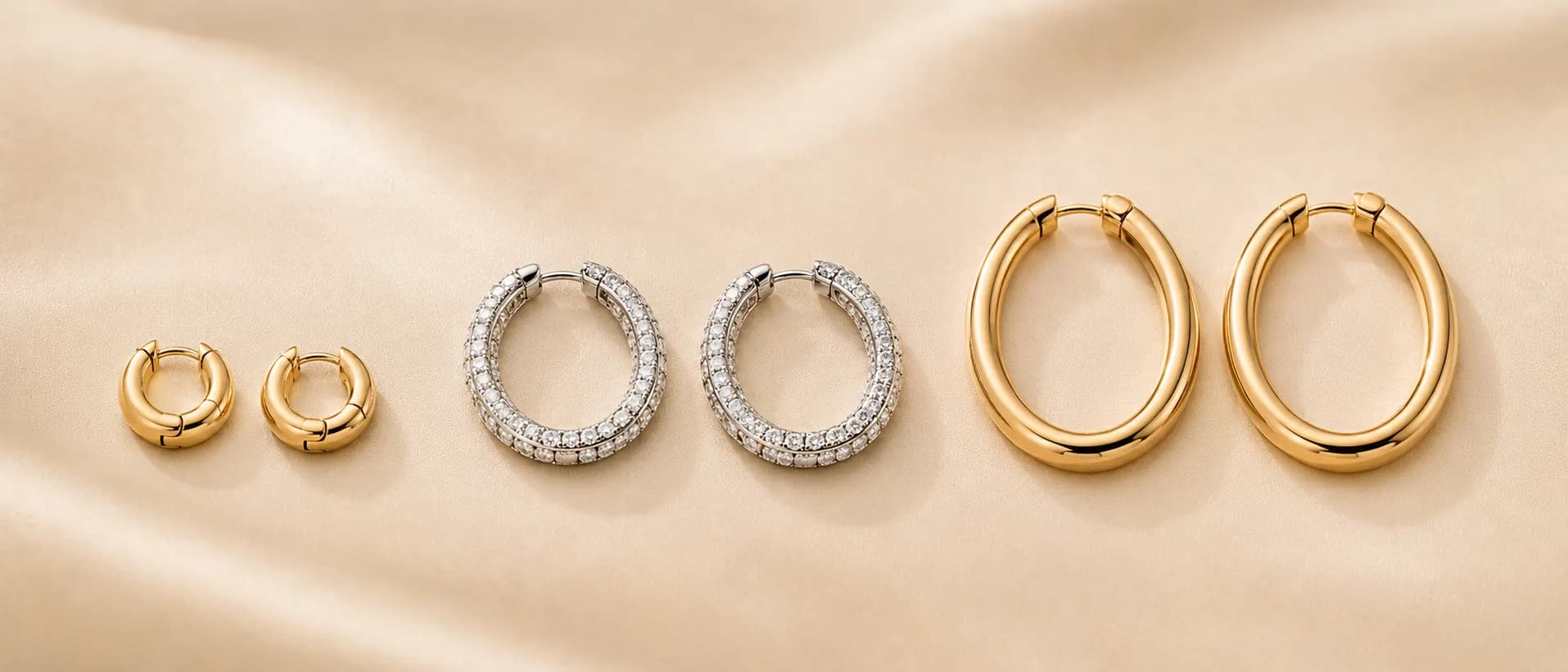 Gold and diamond hoop earrings on cream linen at ATL Luxury Jewelry Atlanta