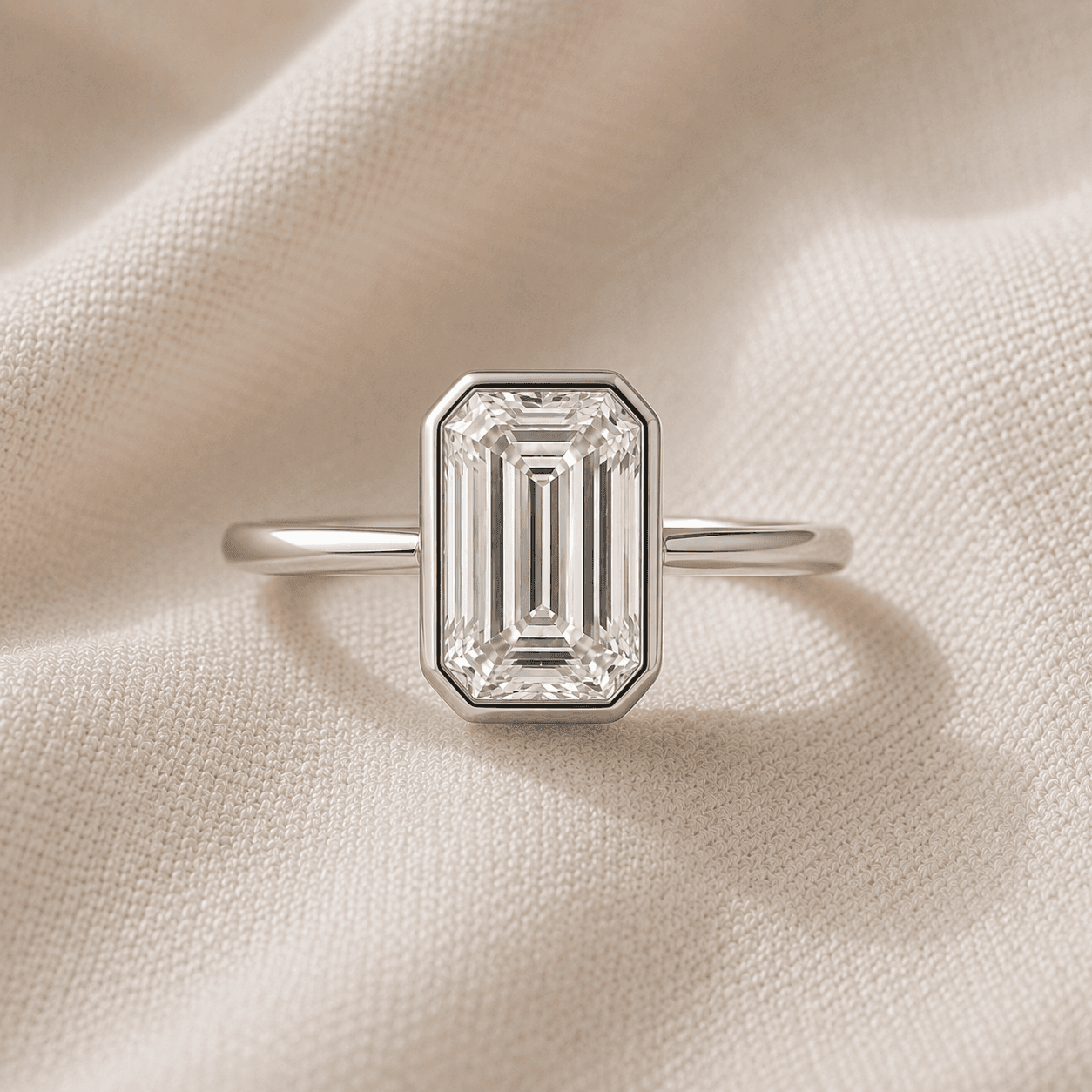Bezel-set emerald cut engagement ring in white gold