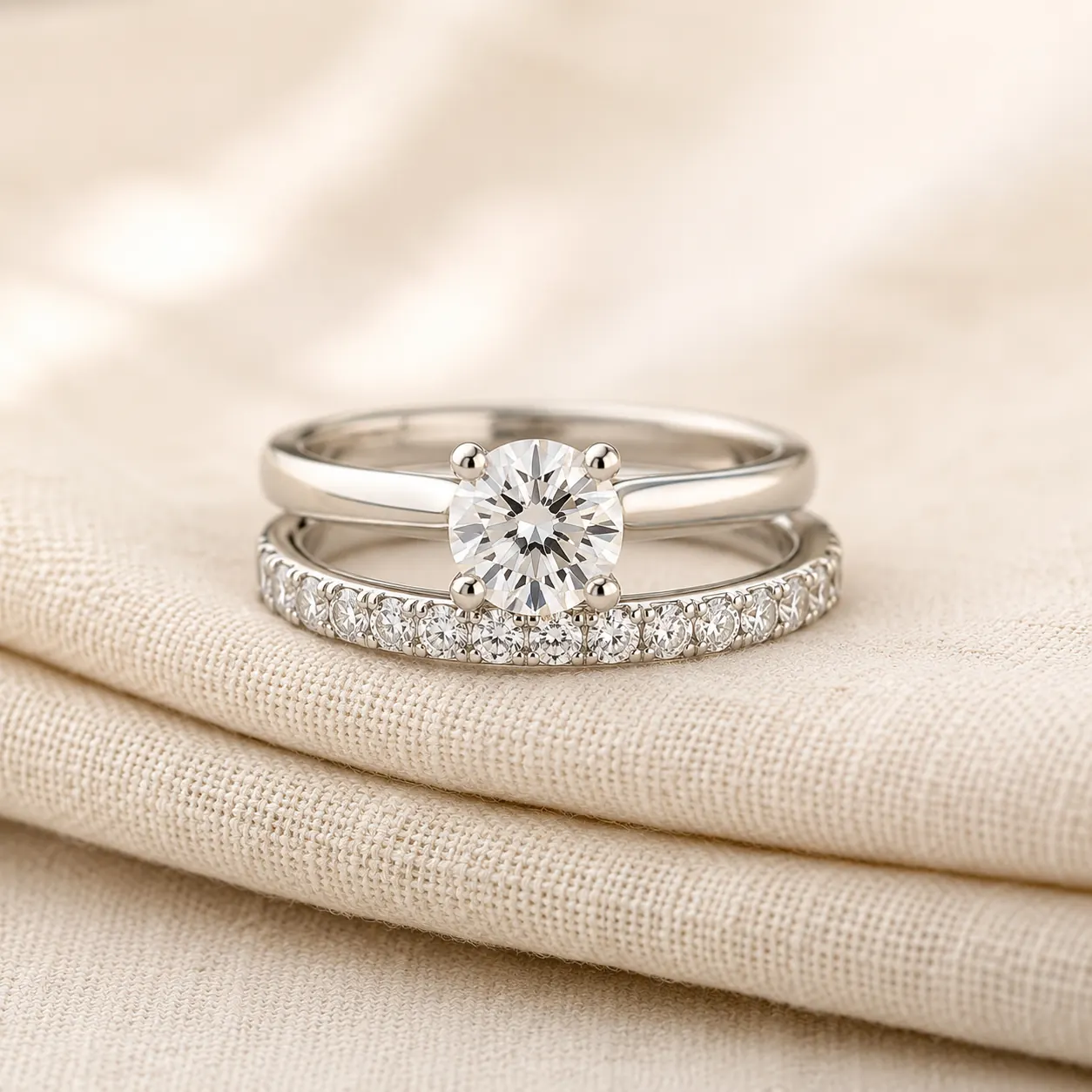 Diamond eternity anniversary band stacked with engagement ring on cream linen at ATL Luxury Jewelry Atlanta