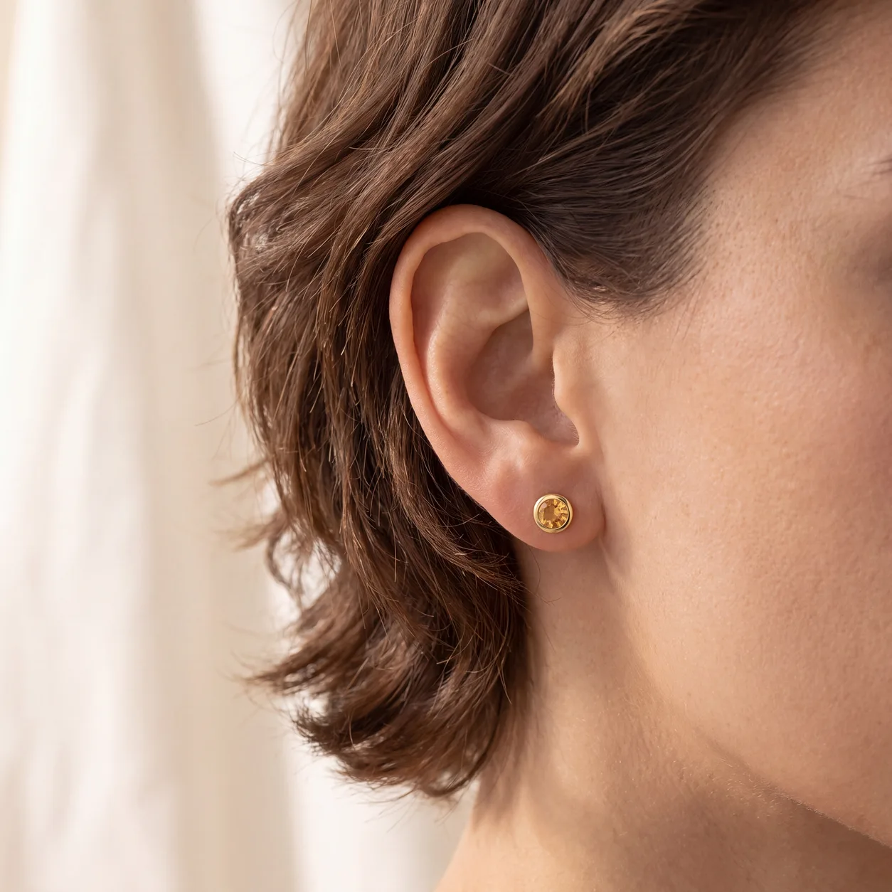 A diamond stud earring resting on a jewelry box lid