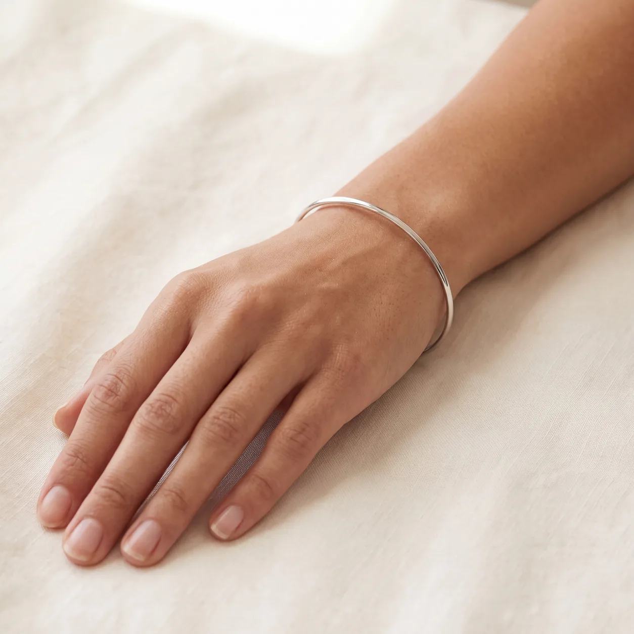 A gold bracelet with an engraved bar charm