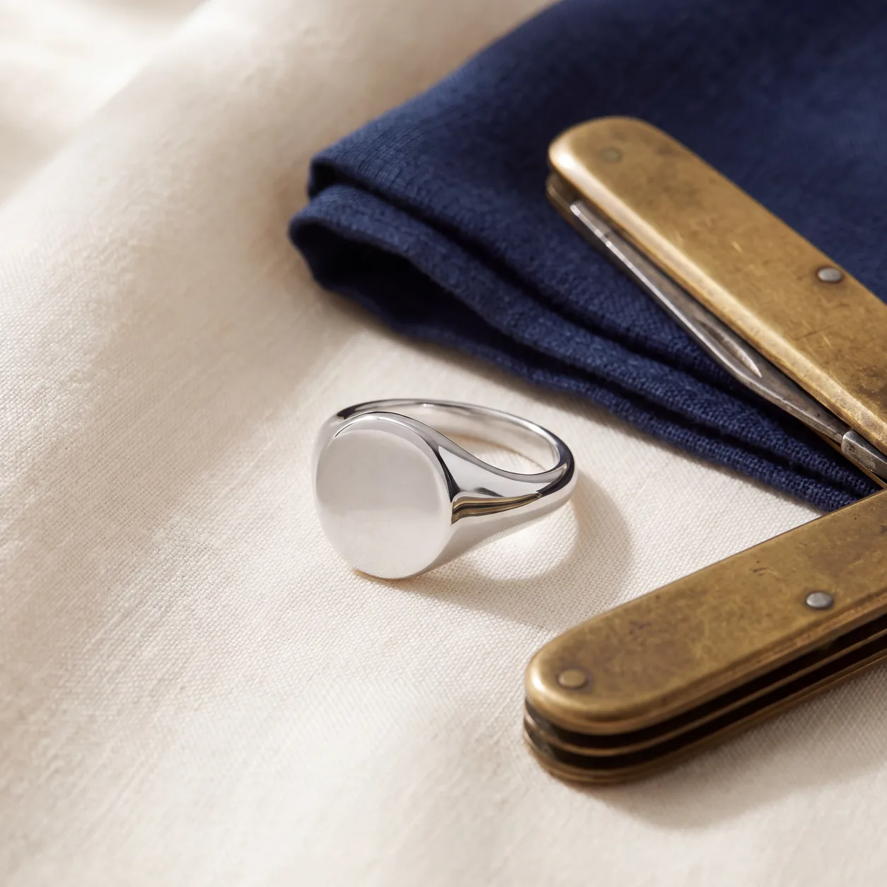 A close view of a men's gold signet ring engraved with initials