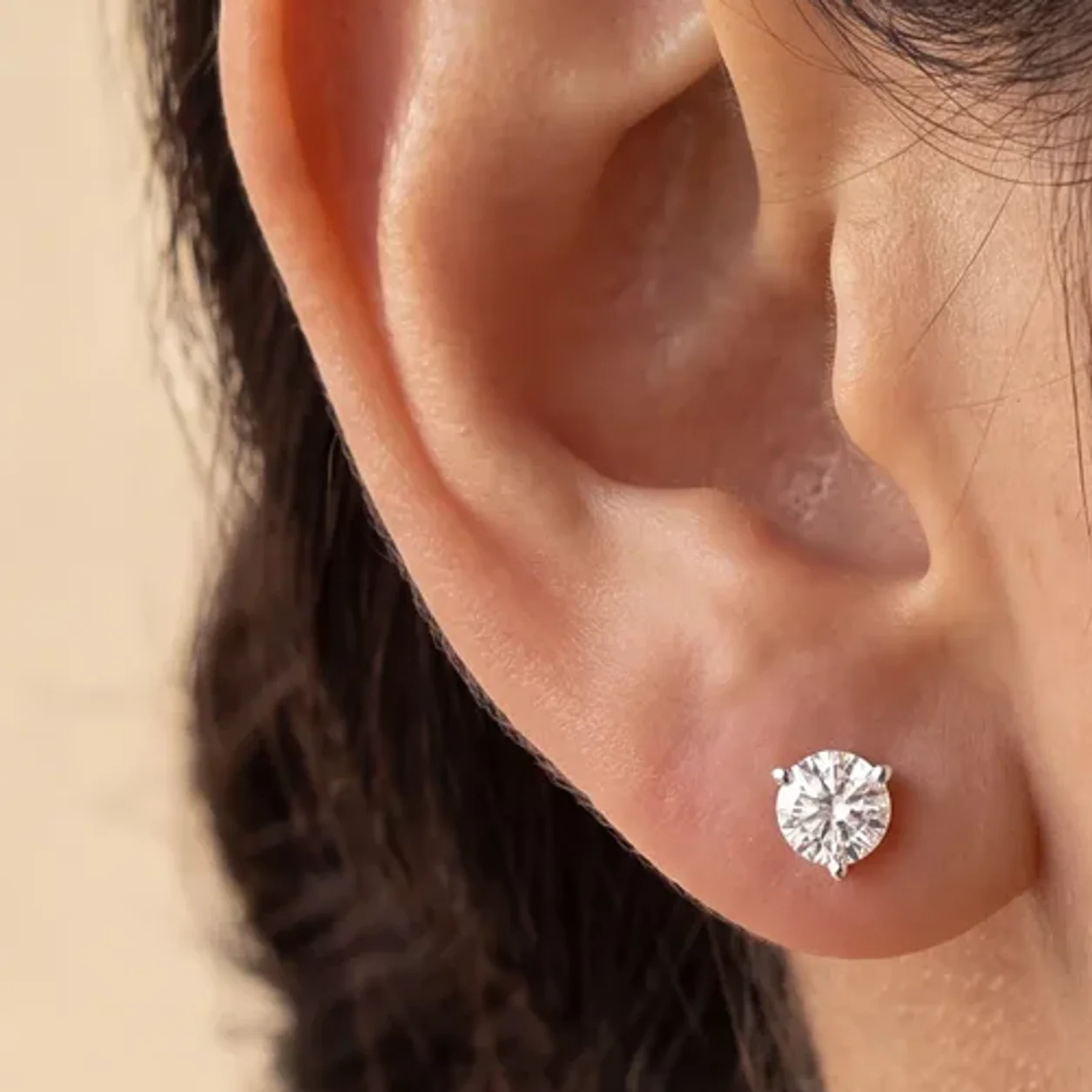 A single diamond stud earring worn on the ear