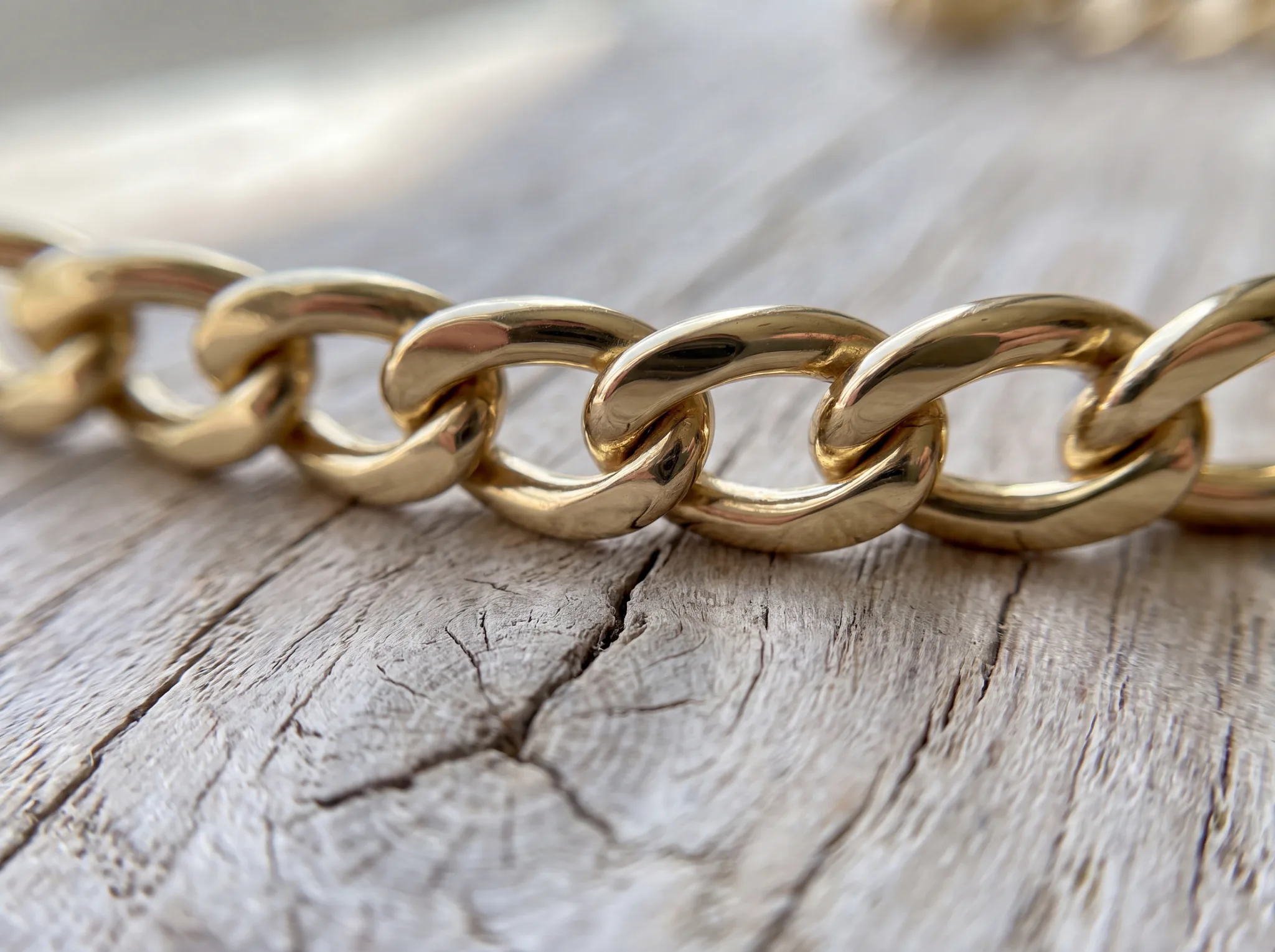 An intact yellow gold curb chain with every link closed and polished, no seam visible