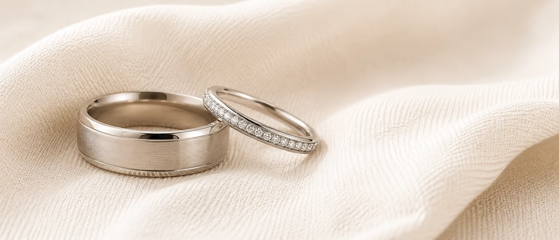 Matching pair of platinum wedding bands resting together on cream linen, handcrafted at ATL Luxury Jewelry in Atlanta