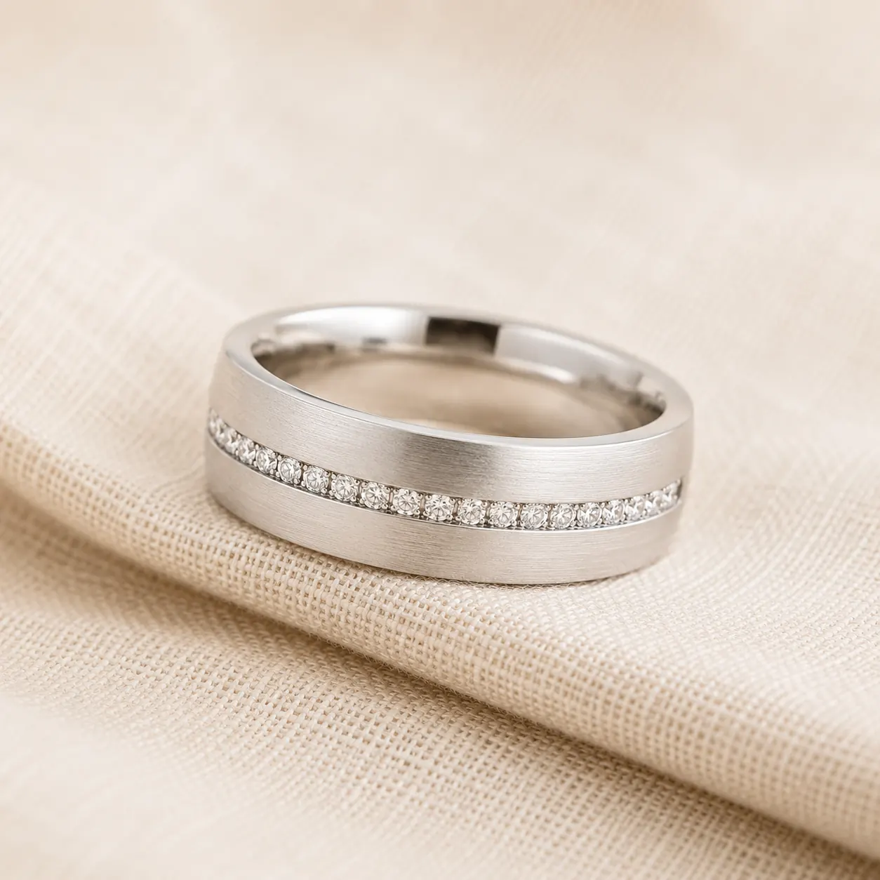 Men’sdiamond wedding band in white gold with flush-set row of diamonds on cream linen at ATL Luxury Jewelry Atlanta