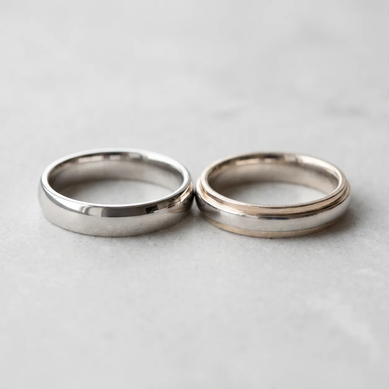 A freshly rhodium-plated white gold band beside one whose plating has worn at the shoulders