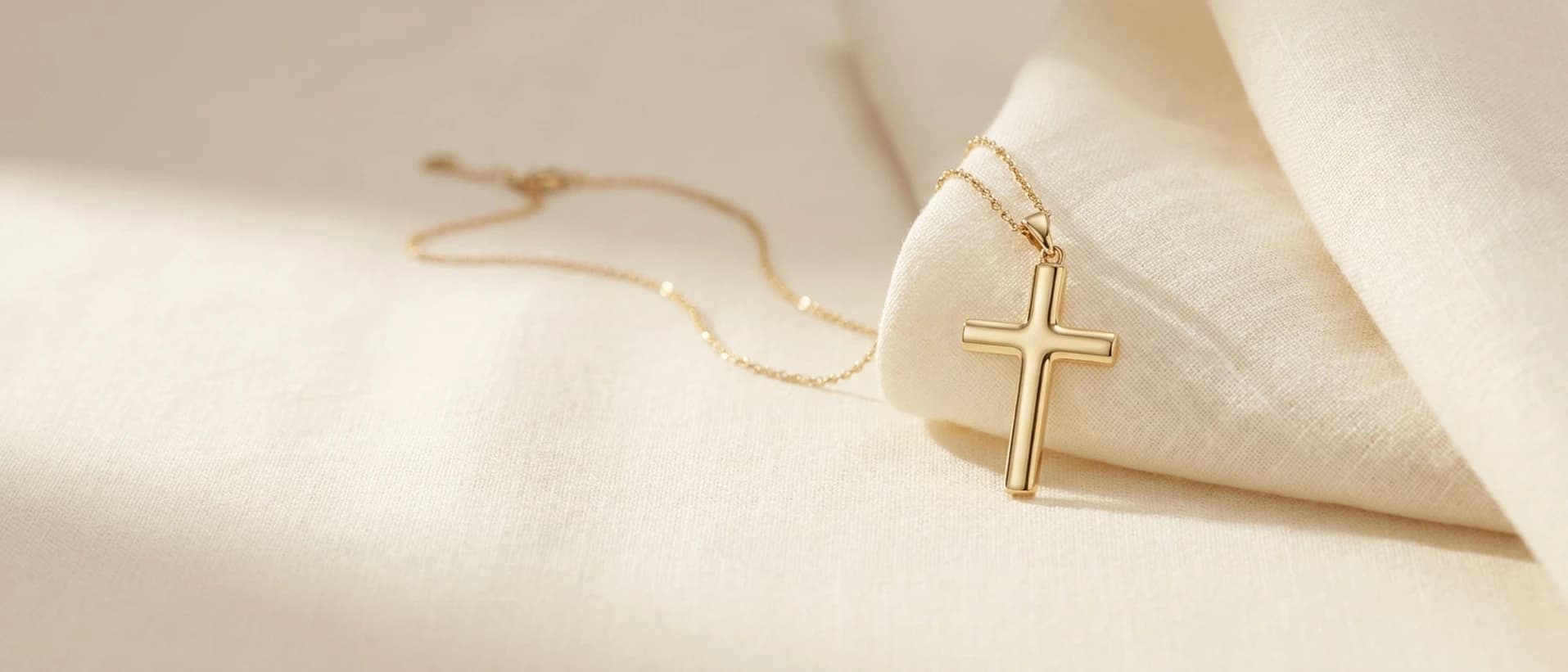 Gold diamond cross pendant on cream linen at ATL Luxury Jewelry Atlanta