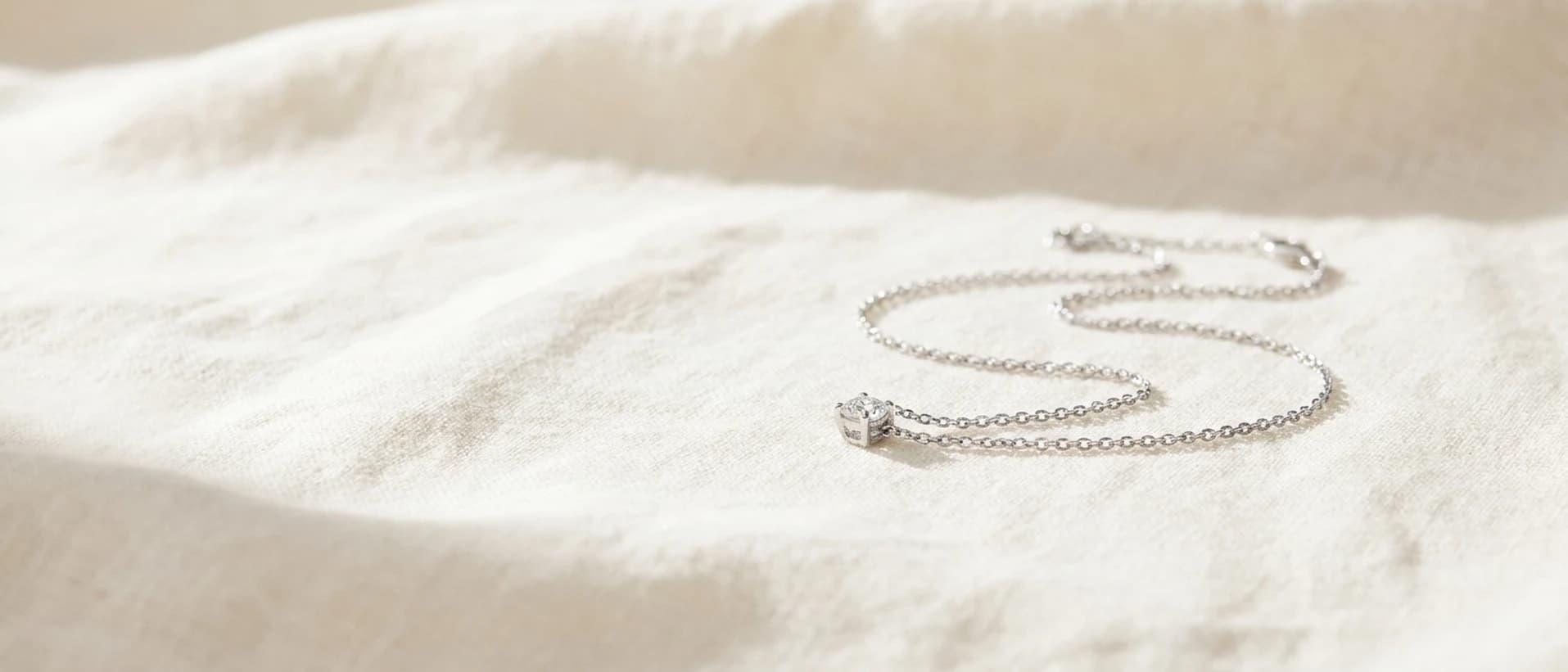 White gold diamond necklace on cream linen at ATL Luxury Jewelry Atlanta