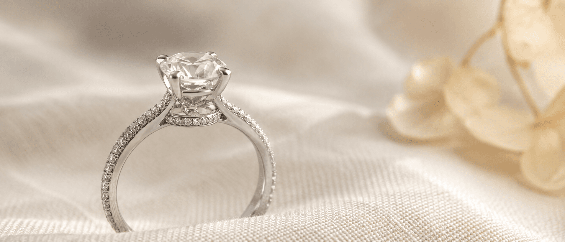 Pavé-band diamond engagement ring with hidden halo on cream linen at ATL Luxury Jewelers Atlanta