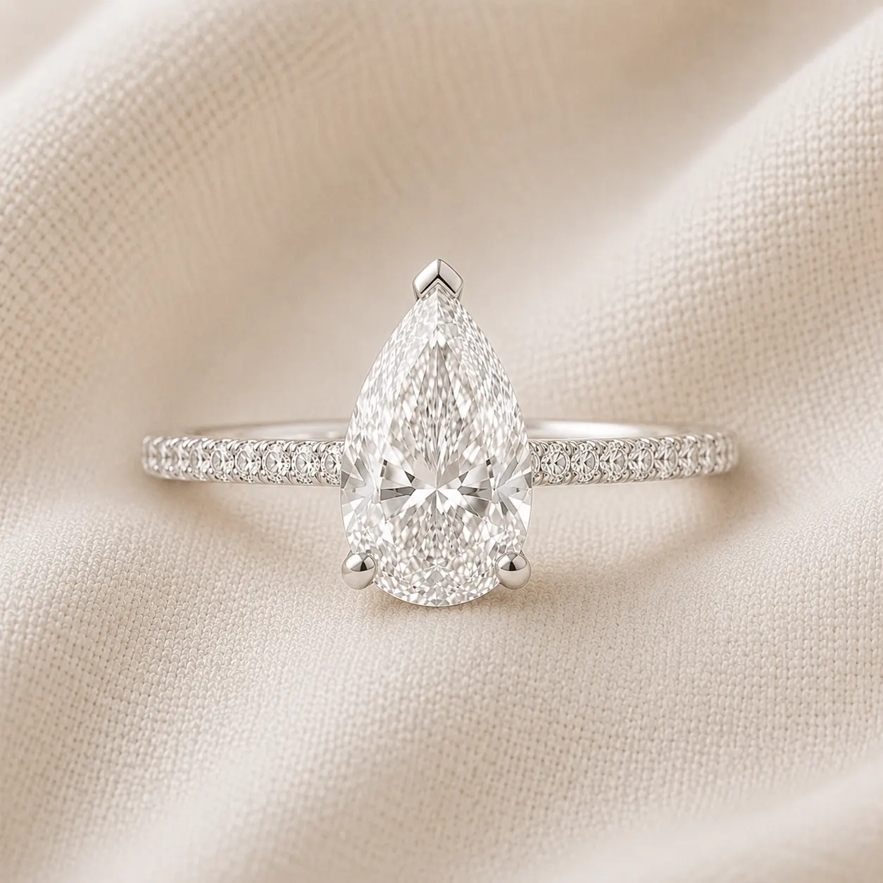 Pear cut engagement ring with pavé diamond band