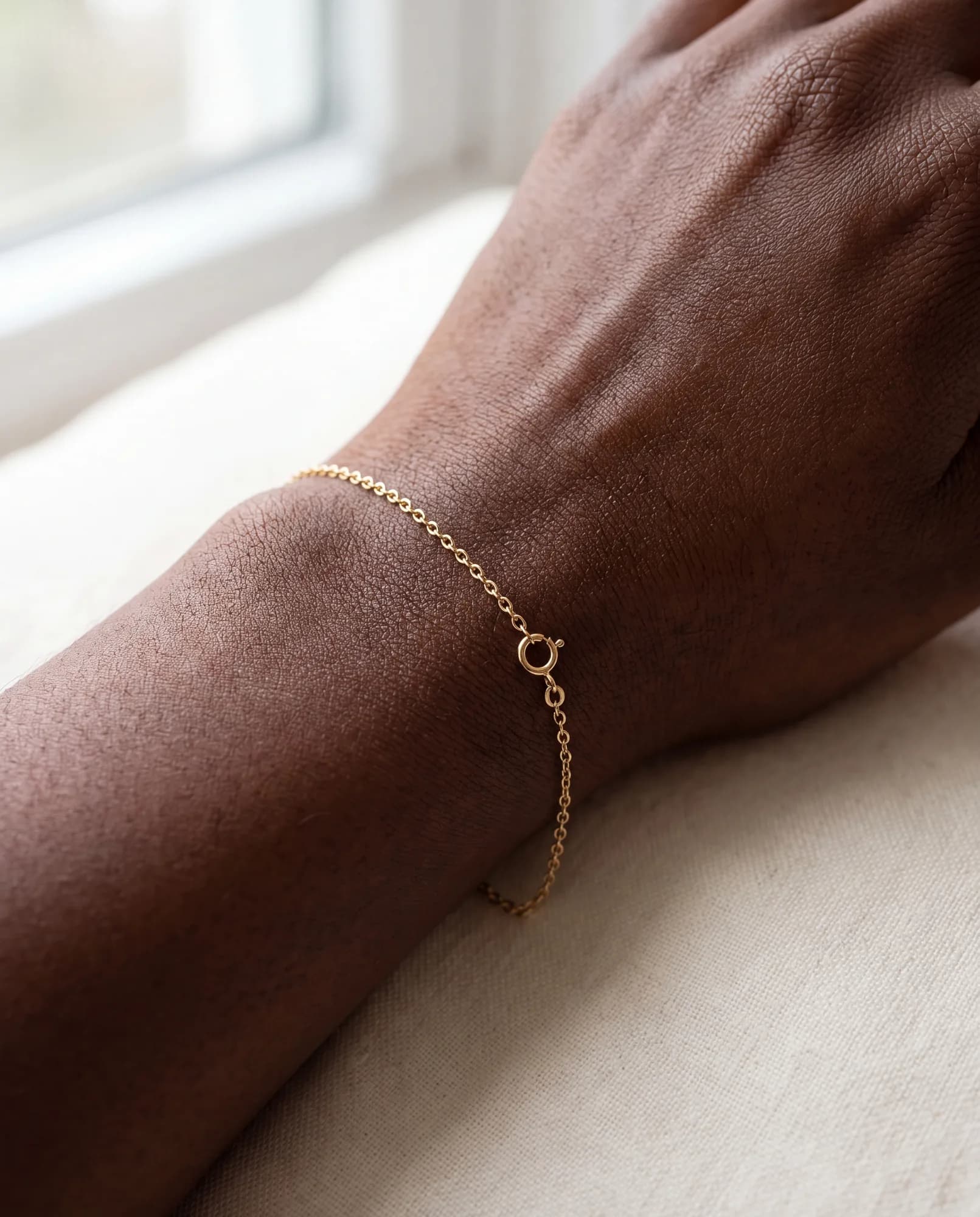 Close-up of a fine cable chain bracelet on a wrist
