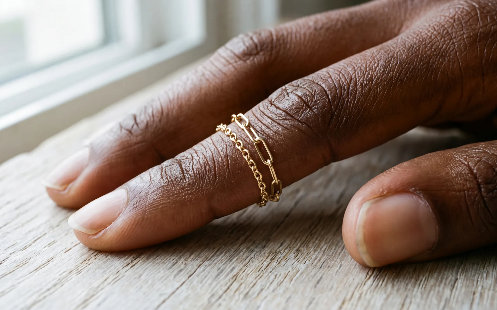 Two fine chain rings stacked together on one finger