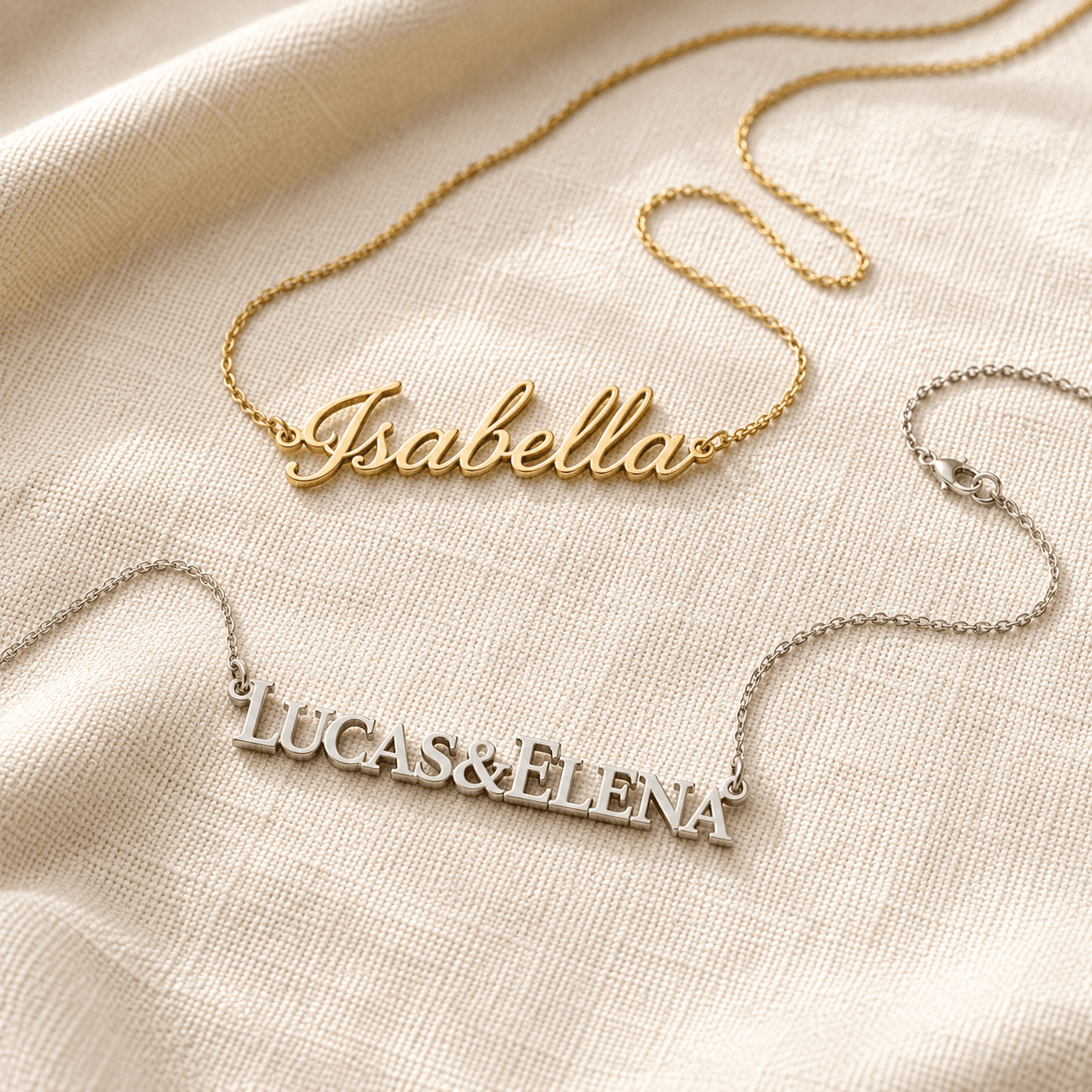 Two-name gold nameplate necklaces in script and block letters on cream linen at ATL Luxury Jewelers Atlanta