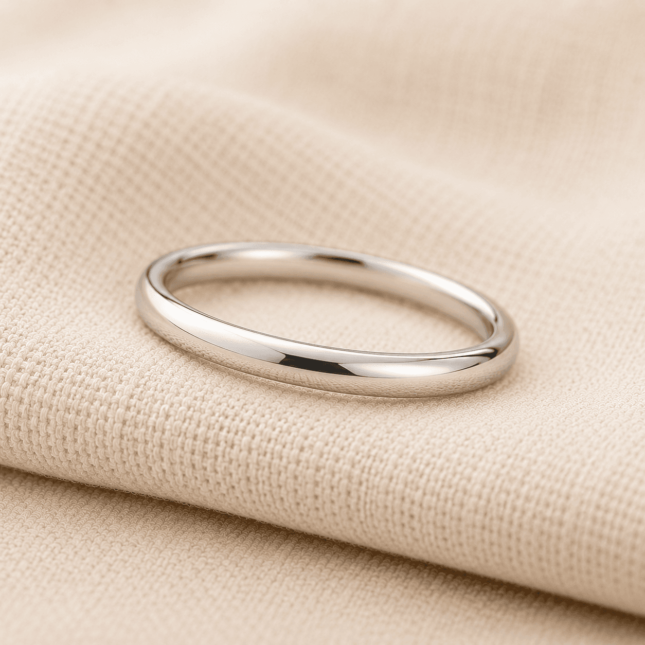 Women's slim platinum wedding band on cream linen at ATL Luxury Jewelers Atlanta