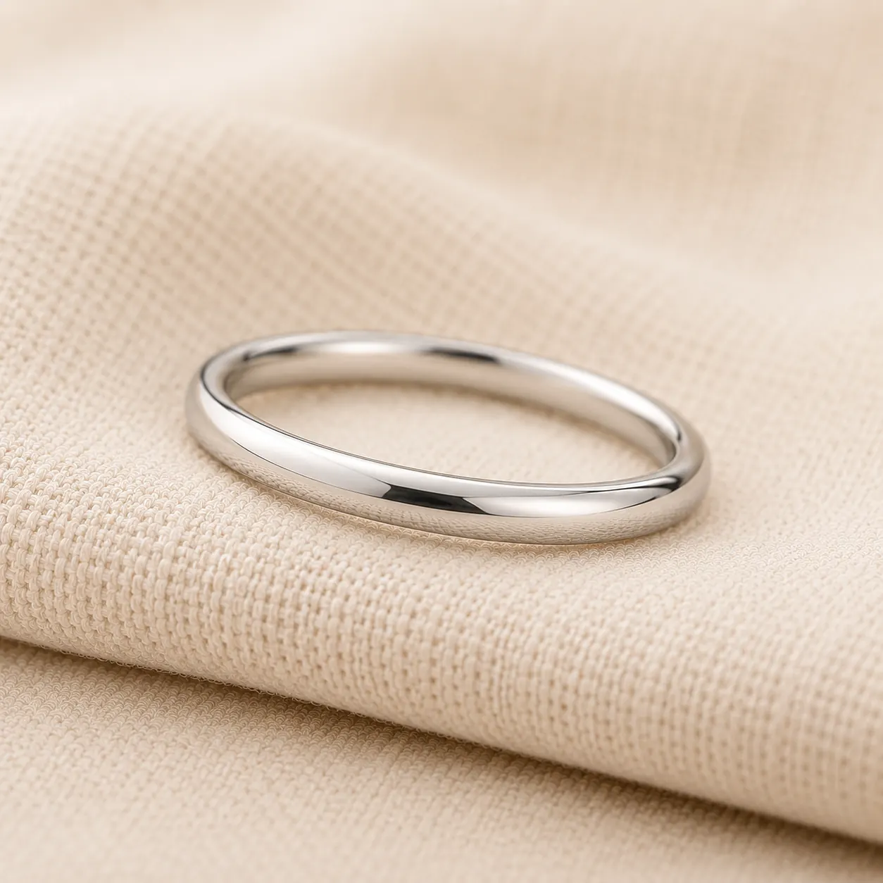 Women's slim platinum wedding band on cream linen at ATL Luxury Jewelry Atlanta