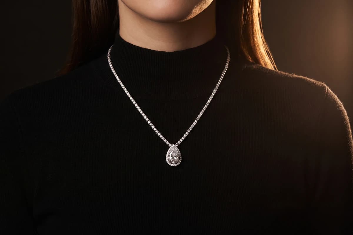 Design prototype — a rendering of a pear-shaped diamond halo pendant worn at the collarbone, a piece ATL Luxury Jewelry can make for you.