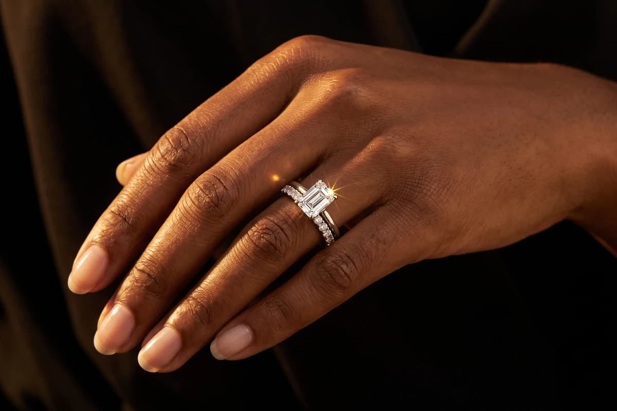 Design prototype — a rendering of an emerald-cut diamond ring stacked with a pavé diamond wedding band, worn on the ring finger, a piece ATL Luxury Jewelry can make for you.