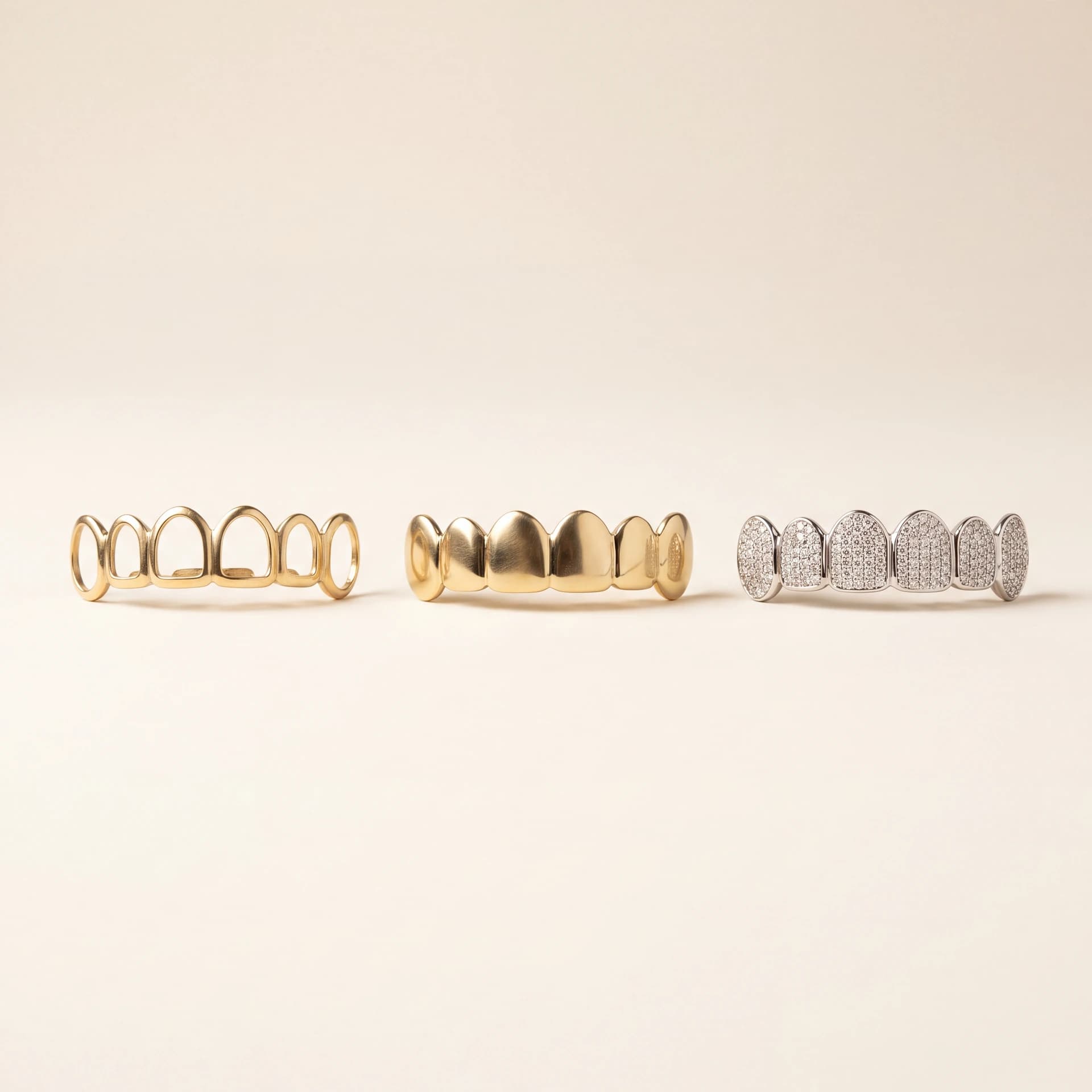 Design prototype — a rendering of three custom grillz styles side by side: open-face, solid, and fully-iced diamond