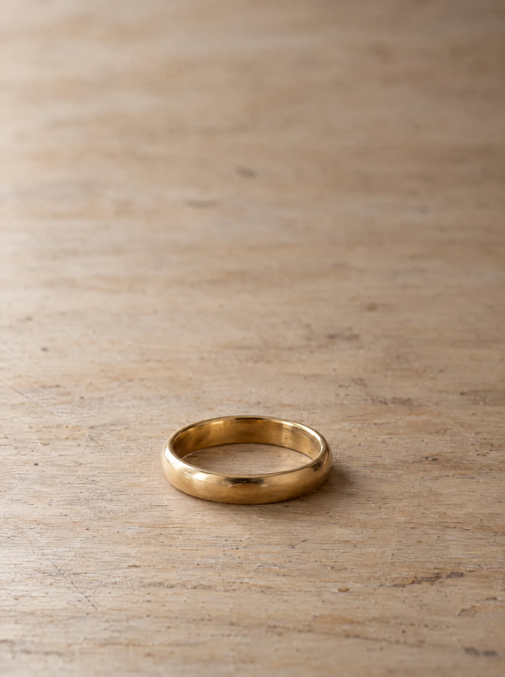 Yellow gold ring resting on a wooden work surface at ATL Luxury Jewelry, Snellville GA