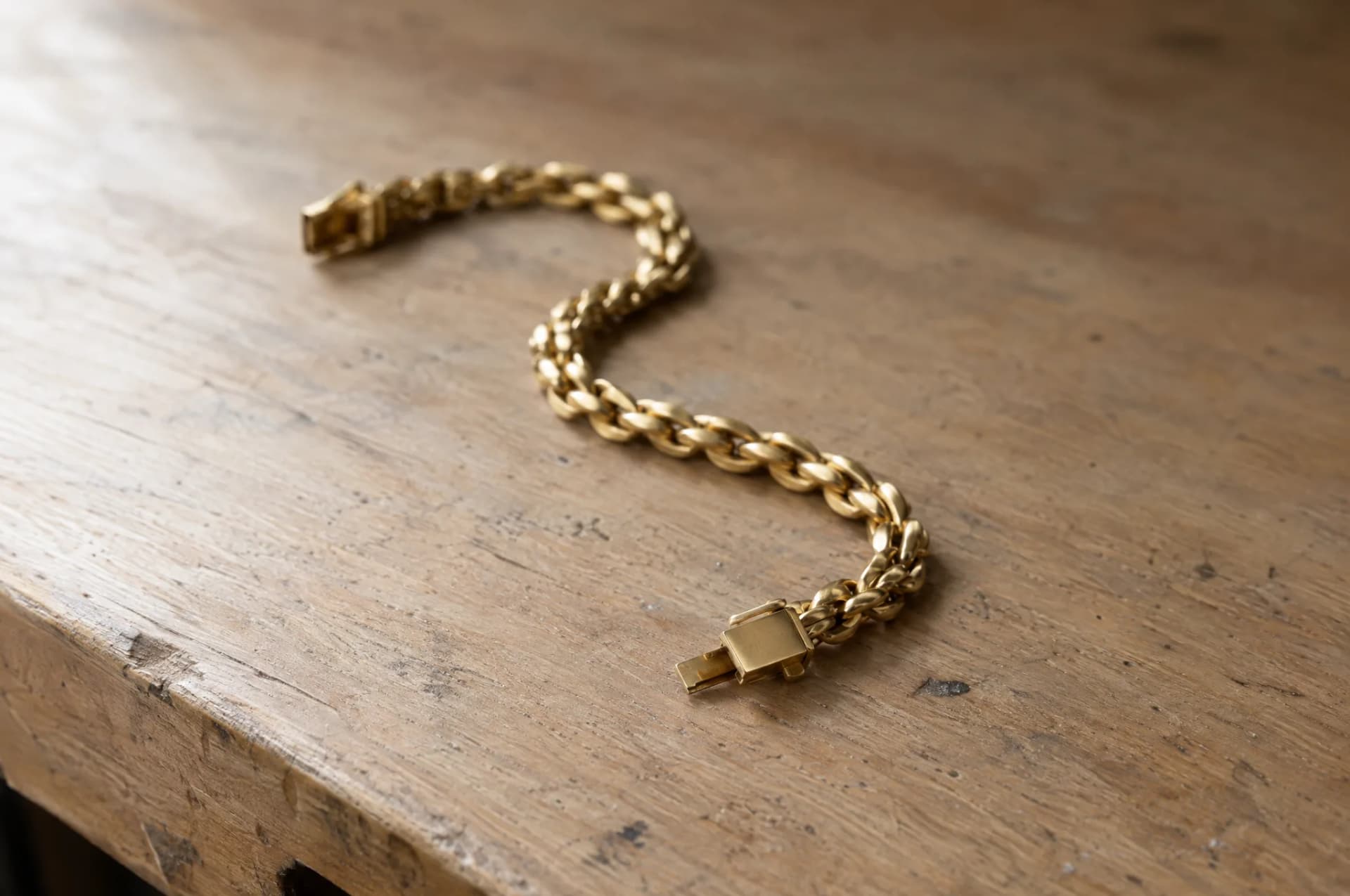 A bracelet resting on a plain wood surface, brought in for repair at ATL Luxury Jewelry, Snellville GA