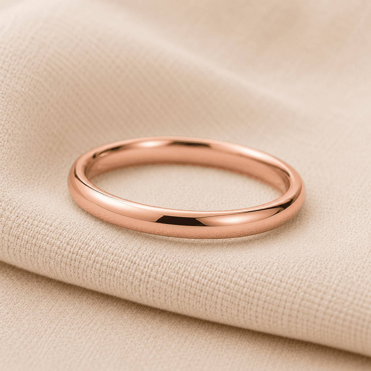 Slim 14K rose gold women's wedding band on cream linen at ATL Luxury Jewelers Atlanta