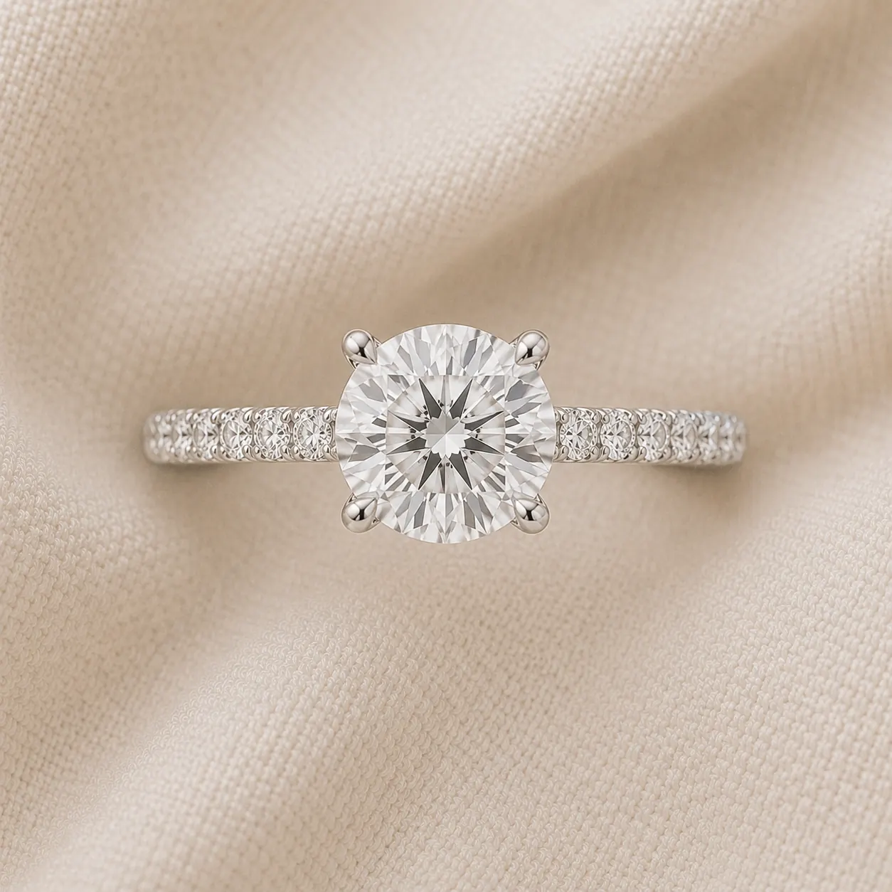 Round brilliant engagement ring with pavé diamond band