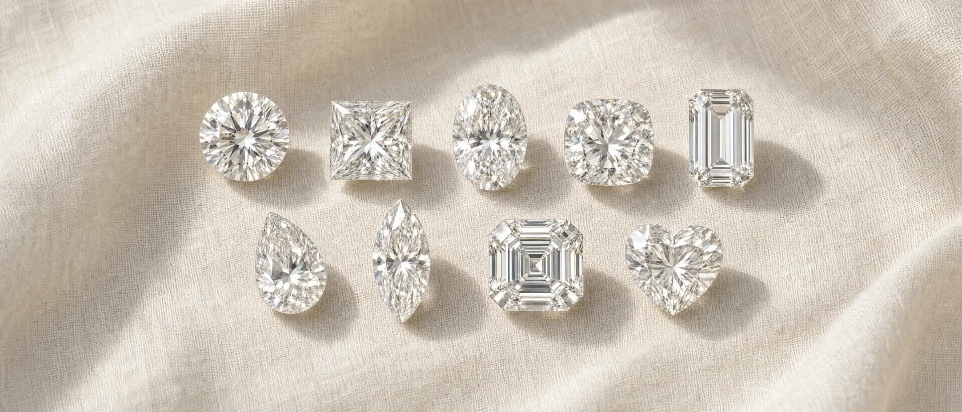 Nine loose diamond shapes on cream linen — round, princess, oval, cushion and emerald cuts above pear, marquise, asscher and heart cuts