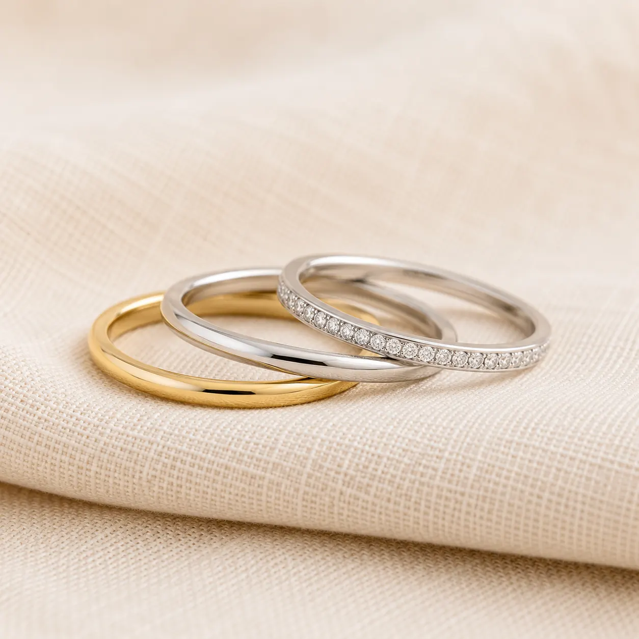 Stackable wedding bands and rings in mixed metals on cream linen at ATL Luxury Jewelry Atlanta