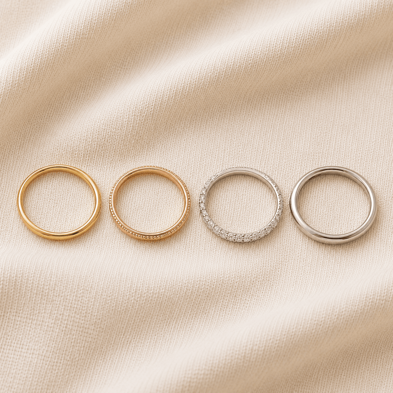 Stackable rings for women in mixed gold metals layered together on cream linen at ATL Luxury Jewelers Atlanta