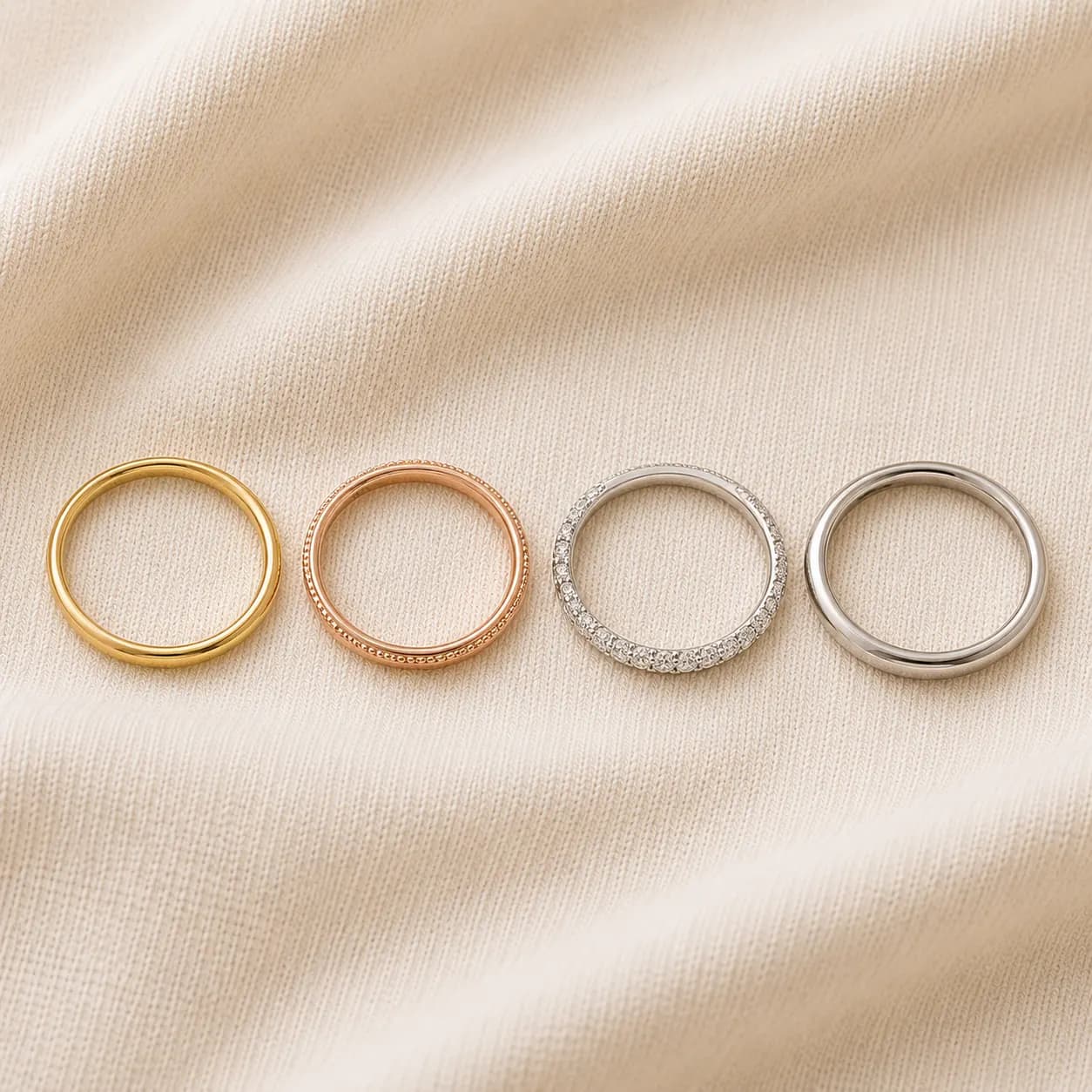 Stackable rings for women in mixed gold metals layered together on cream linen at ATL Luxury Jewelry Atlanta