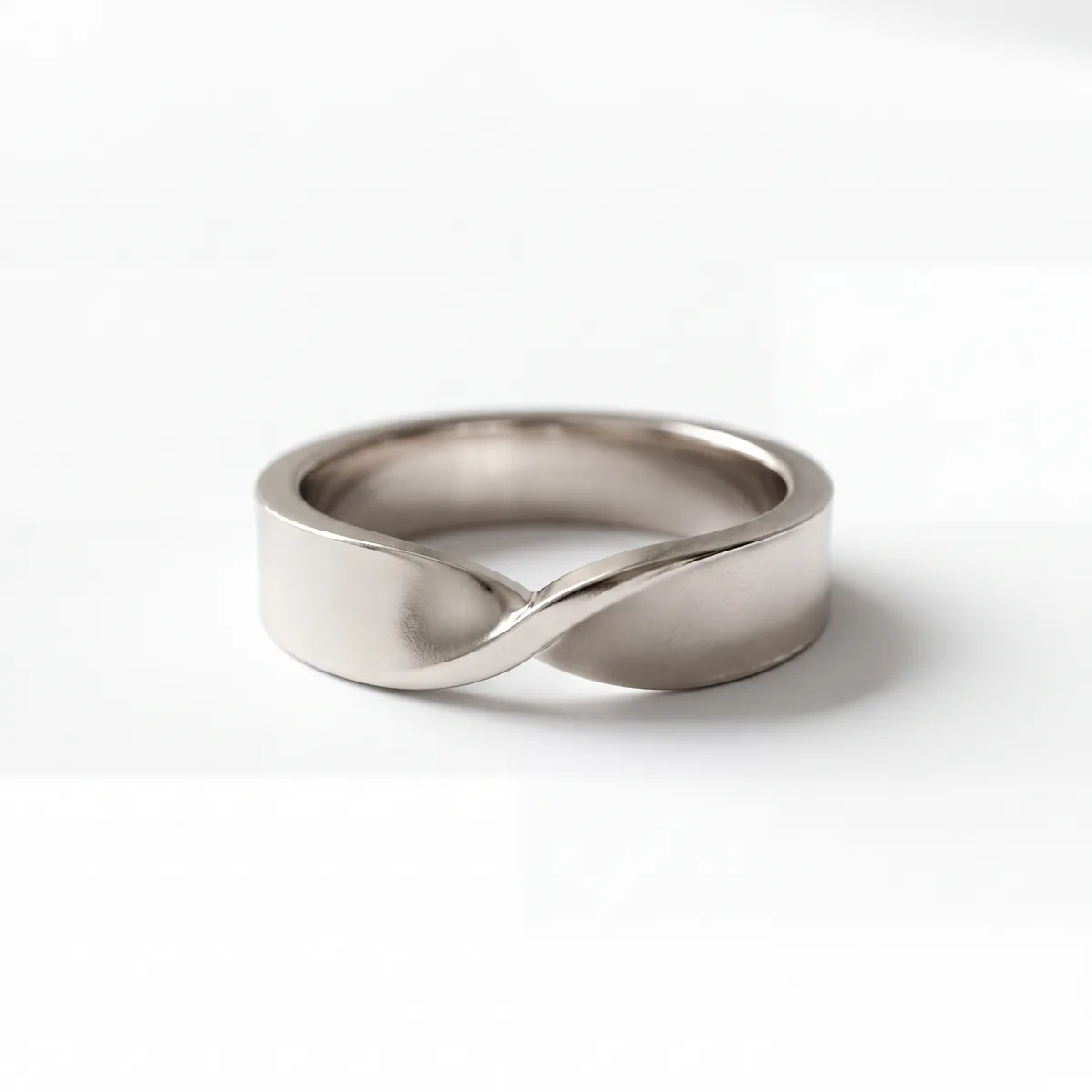 A wide polished band with a single twist on a pale background