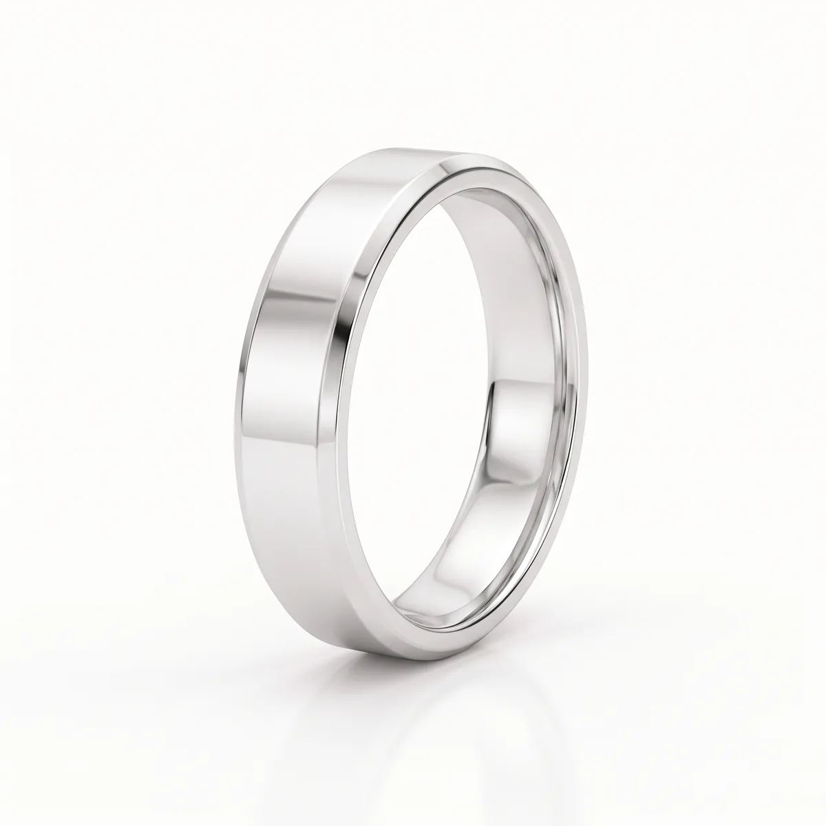 A white gold comfort-fit wedding band with bevelled edges, seen at a slight angle on a pale background