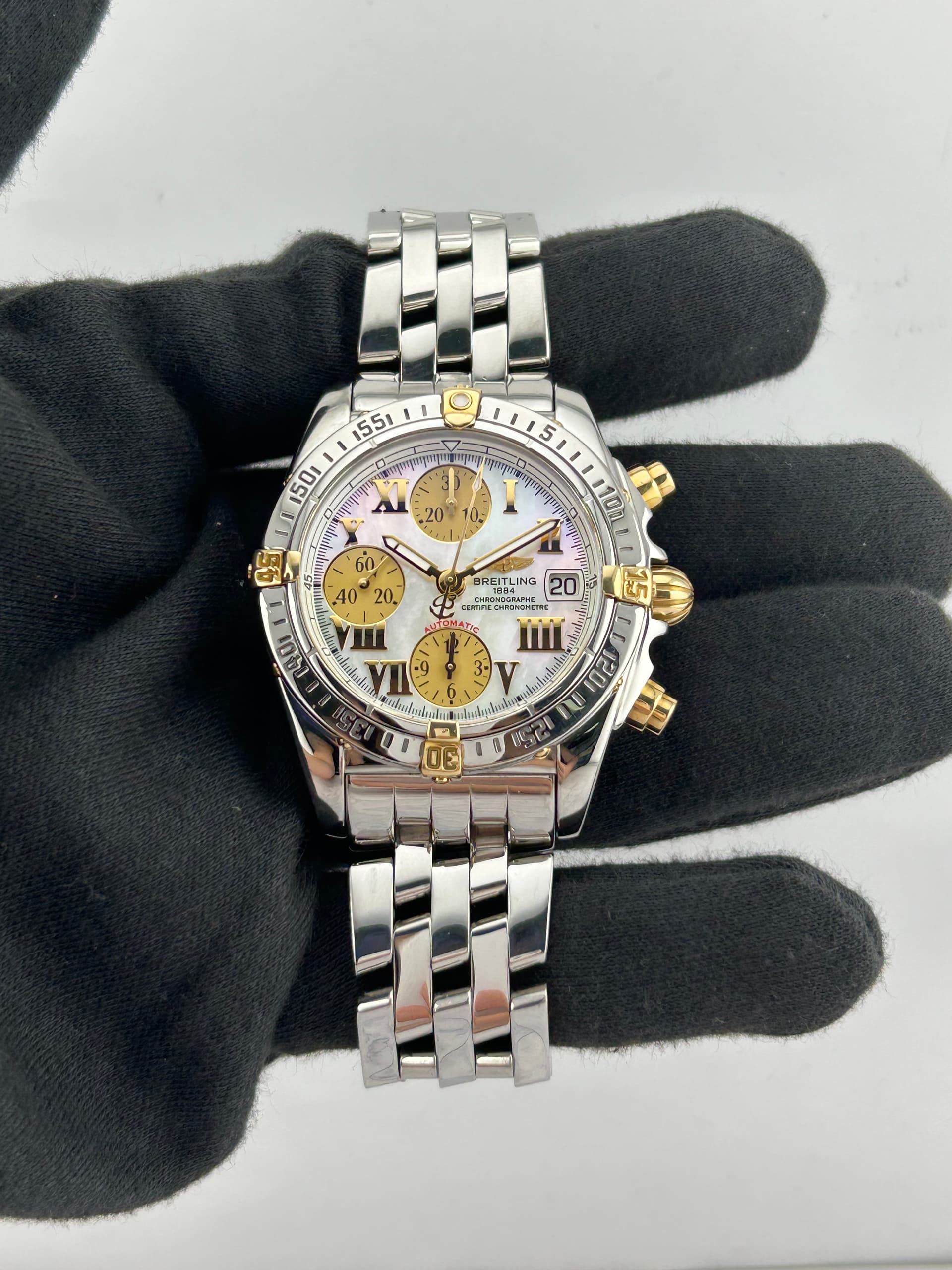 Breitling Chrono Cockpit White M.O.P. Dial on Stainless Steel Ref. B13357 with Papers 2005 — 39mm Stainless Steel case, White M.o.p. dial, Stainless Steel bracelet. Good, 2005. OG Box (Good, slight flaking/peeling on pillow and inside).
